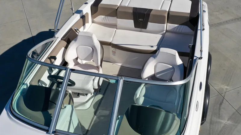 Slide: The Image of The image shows a 2020 Chaparral 19 SSi boat with white and beige seating. - 10