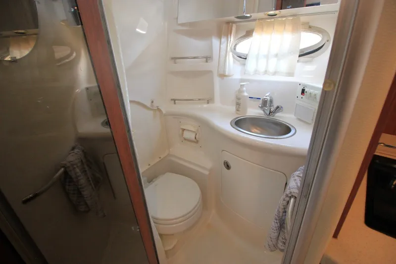 Slide: The Image of Compact bathroom in 2004 Chaparral Signature 310 yacht with sink, toilet, and window. - 21