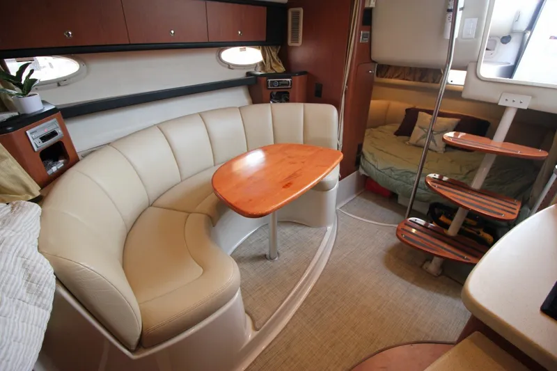 Slide: The Image of Interior of 2004 Chaparral Signature 310 yacht with curved seating and wooden table. - 20