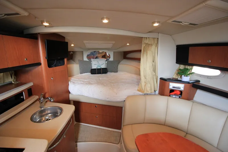 Slide: The Image of 2004 Chaparral Signature 310 cabin interior with bed, kitchenette, and seating area. - 16