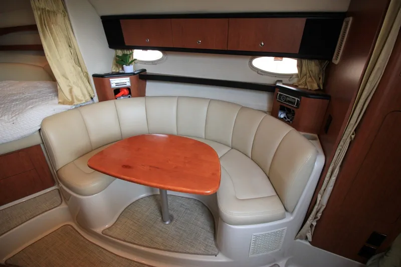 Slide: The Image of 2004 Chaparral Signature 310 interior with beige seating and wooden table. - 15
