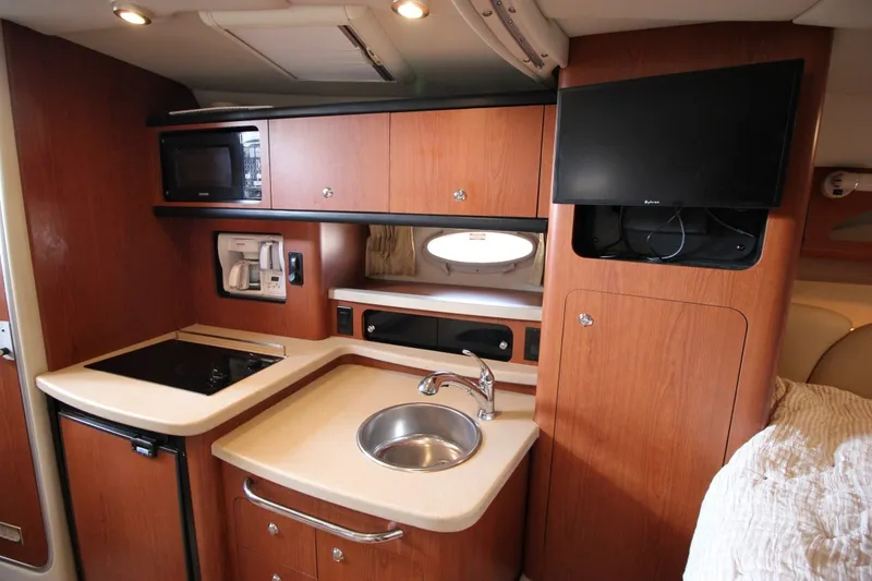 Slide: The Image of 2004 Chaparral Signature 310 boat interior with kitchenette and TV. - 19