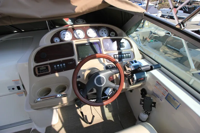 Slide: The Image of 2004 Chaparral Signature 310 boat helm with gauges, steering wheel, and controls. - 13