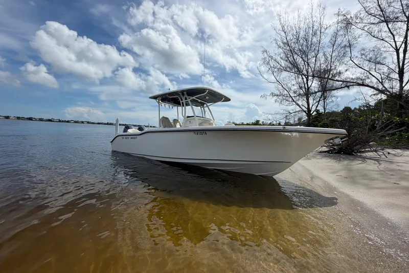 Slide: The Image of 2022 Key West 263 FS boat on sandy shore under blue sky. - 3