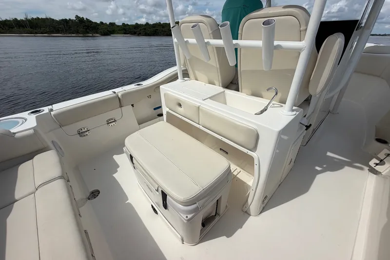 Slide: The Image of 2022 Key West 263 FS boat interior with seating and storage, near a calm waterway. - 9