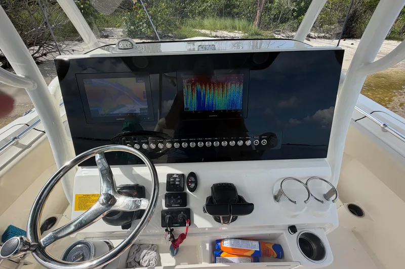 Slide: The Image of 2022 Key West 263 FS boat dashboard with steering wheel and navigation screens. - 12