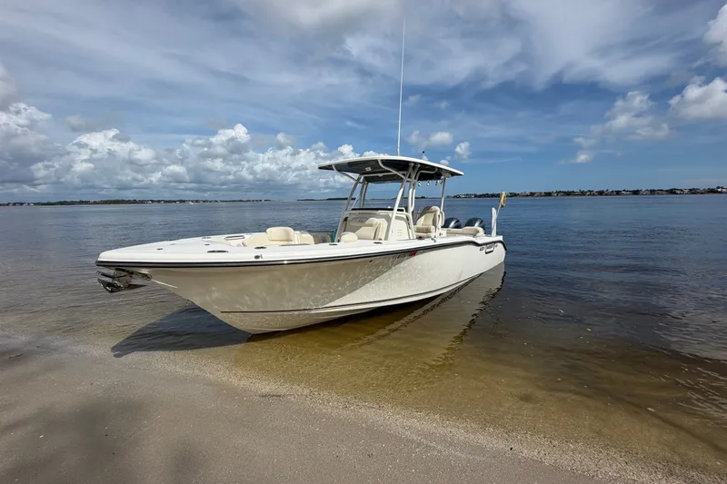 Slide: The Image of 2022 Key West 263 FS boat on sandy shore under blue sky. - 1