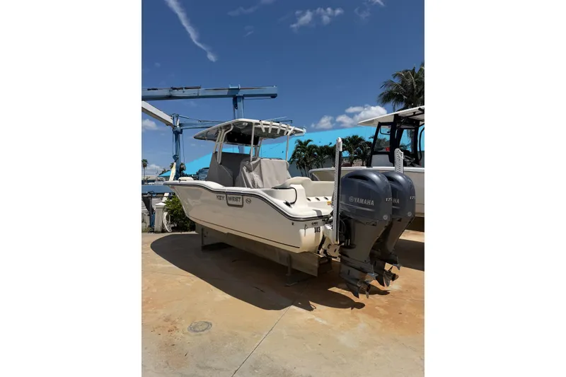 Slide: The Image of 2022 Key West 263 FS boat with dual Yamaha engines, parked outdoors under a clear sky. - 2