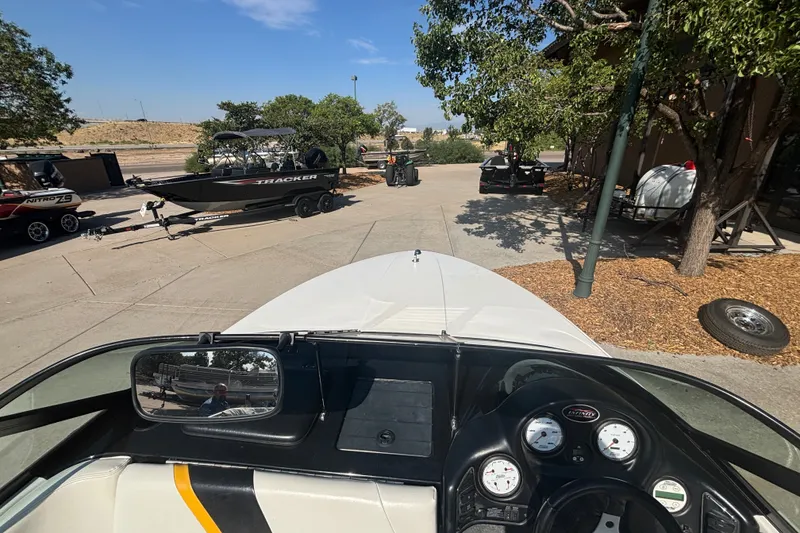 Slide: The Image of Boat dashboard view with parked Tracker boats and trailers in a sunny outdoor setting. - 15