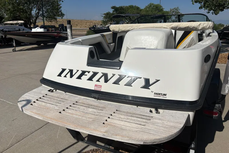 Slide: The Image of 2001 Infinity ZX-1 boat rear view with swim platform, parked outdoors. - 4