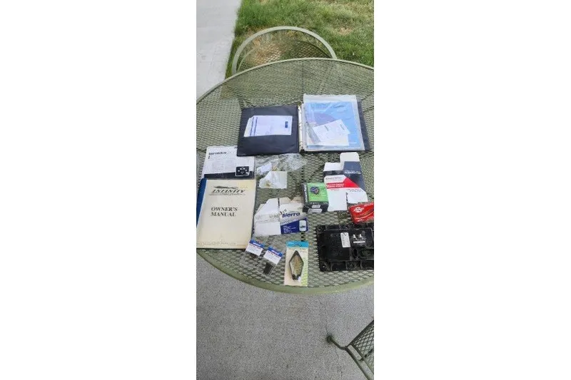 Slide: The Image of Assorted Infinity ZX-1 2001 manuals and parts on a round outdoor table. - 22