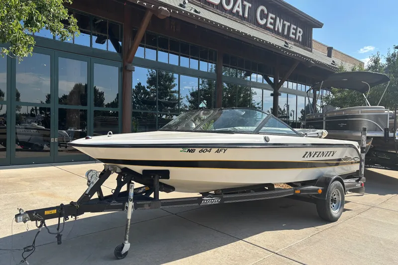 Slide: The Image of 2001 Infinity ZX-1 boat on trailer outside a boat center. - 1