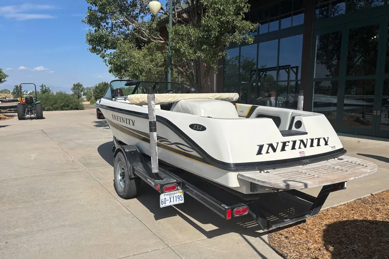 Slide: The Image of 2001 Infinity ZX-1 boat on trailer, parked outdoors near a building. - 3