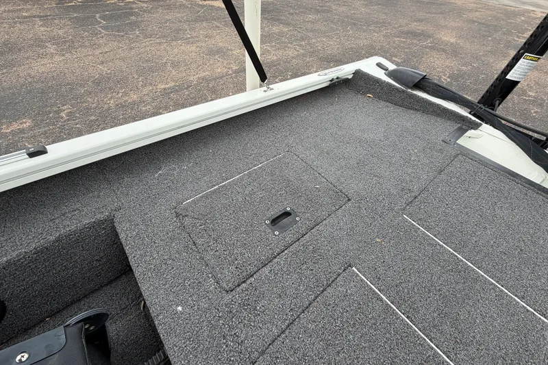 Slide: The Image of 2022 Crestliner XF 189 boat deck with gray carpet and storage hatch. - 28