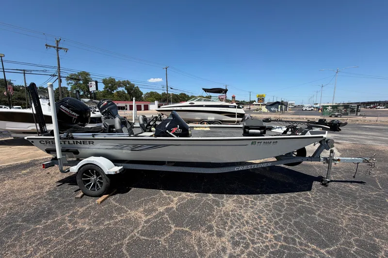 The Image of 2022 Crestliner XF 189 boat on trailer, parked outdoors under clear blue sky. - 0