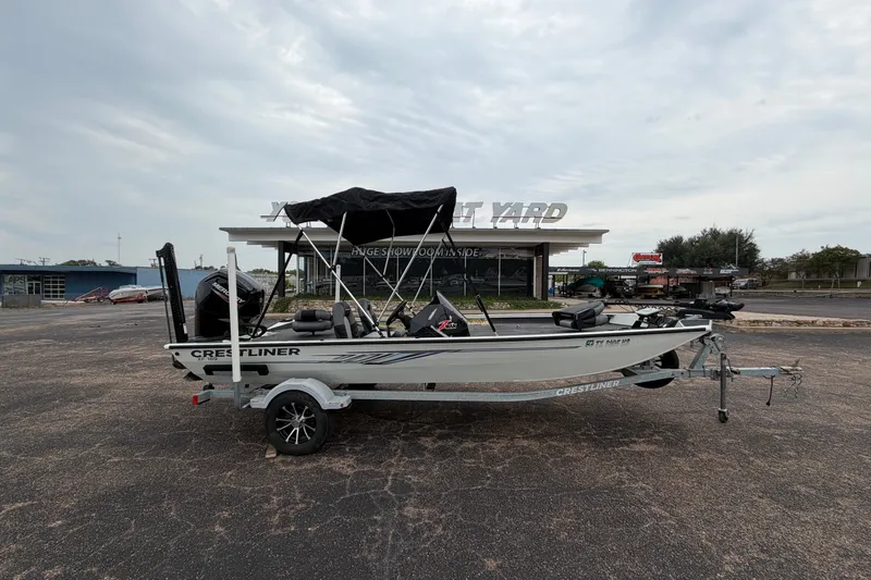 Slide: The Image of 2022 Crestliner XF 189 boat on trailer, parked outside dealership under cloudy sky. - 3