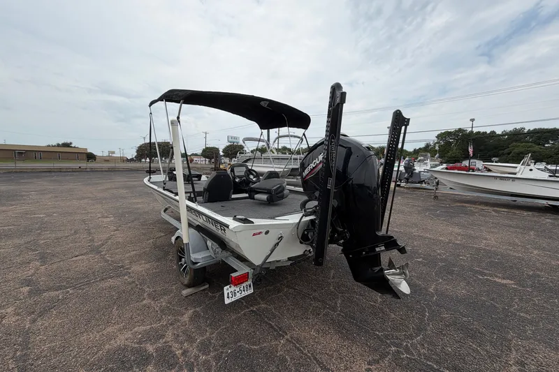 Slide: The Image of 2022 Crestliner XF 189 boat with Mercury engine, parked on a paved lot under cloudy skies. - 7