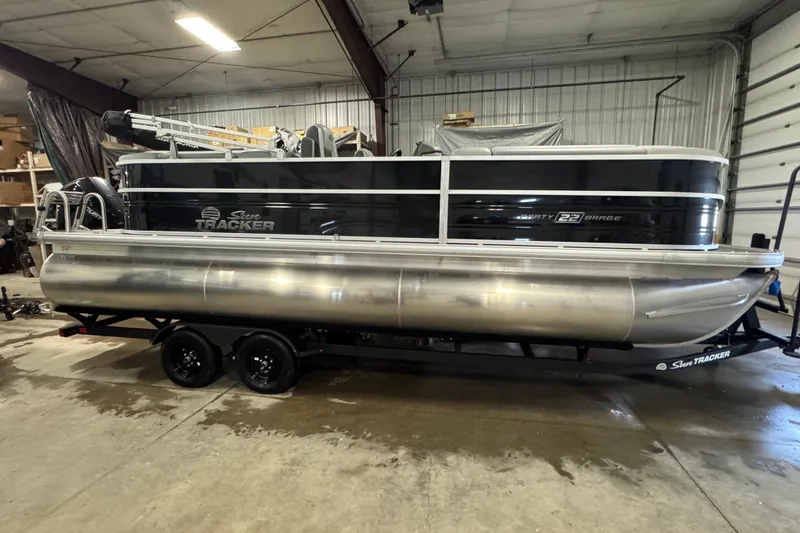 The Image of 2026 Sun Tracker Party Barge 22 XP3 pontoon boat in indoor storage. - 0
