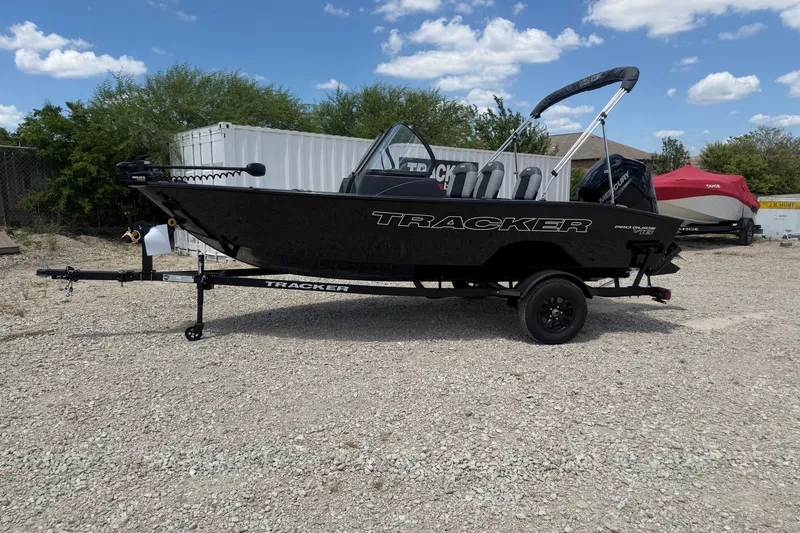The Image of 2027 Tracker Pro Guide V-16 WT boat on trailer, parked outdoors under a blue sky. - 0