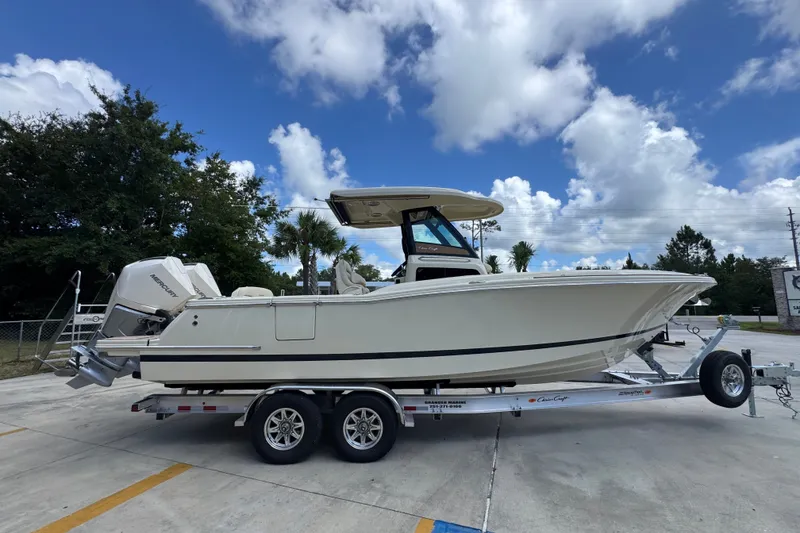 Slide: The Image of 2027 Chris-Craft Catalina 28 boat on trailer under a blue sky with clouds. - 11