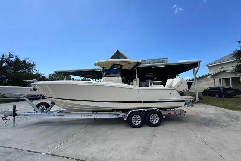 The Image of 2027 Chris-Craft Catalina 28 boat on trailer, parked outdoors under clear blue sky. - 1