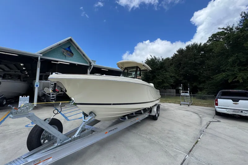 Slide: The Image of 2027 Chris-Craft Catalina 28 boat on trailer outside a marina under a blue sky. - 4
