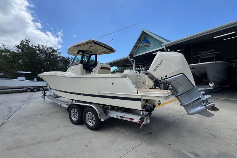 Slide: The Image of 2027 Chris-Craft Catalina 28 boat on trailer, parked outdoors near a building. - 19