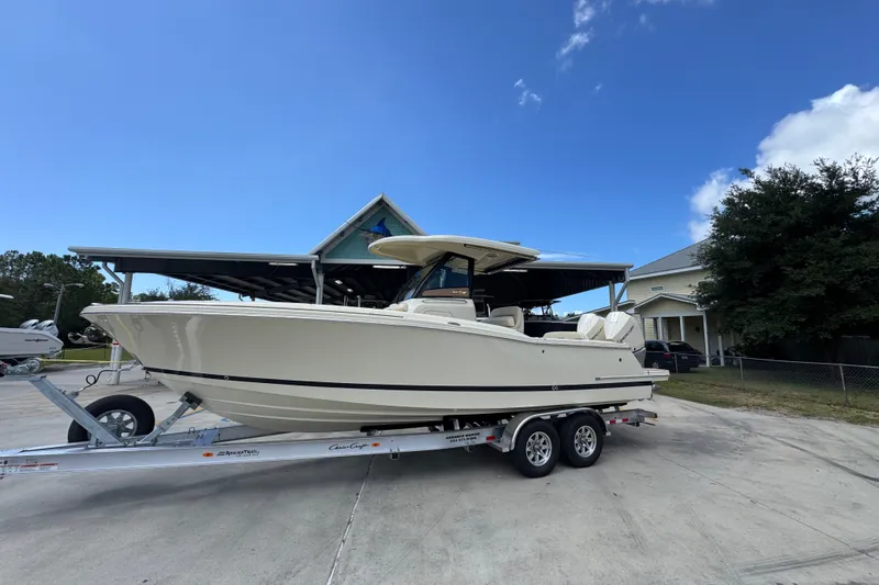 Slide: The Image of 2027 Chris-Craft Catalina 28 boat on trailer, parked outdoors under clear blue sky. - 2