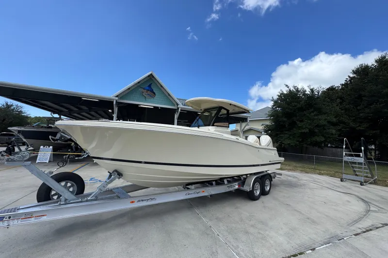 Slide: The Image of 2027 Chris-Craft Catalina 28 boat on trailer, parked outdoors under clear blue sky. - 3