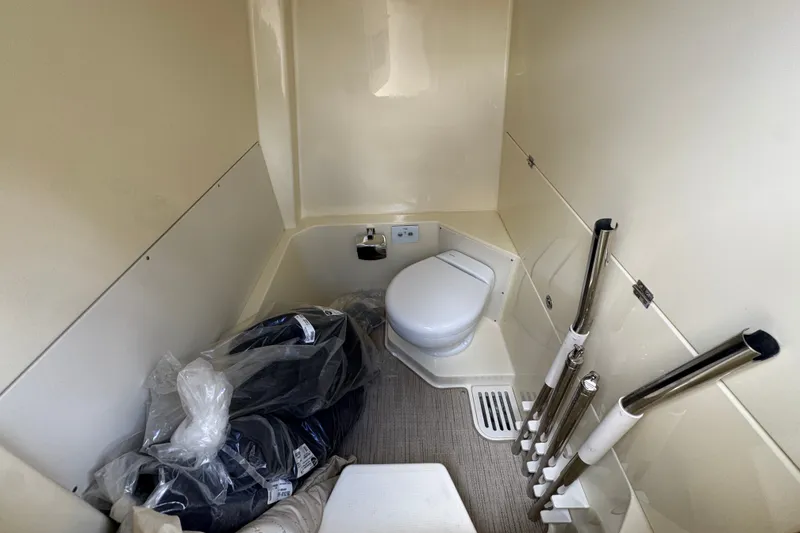 Slide: The Image of Interior of 2027 Chris-Craft Catalina 28 boat bathroom with toilet and storage space. - 29