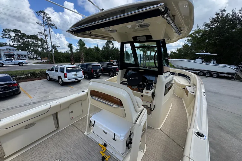 Slide: The Image of 2027 Chris-Craft Catalina 28 boat interior with helm, seating, and storage, parked outdoors. - 39