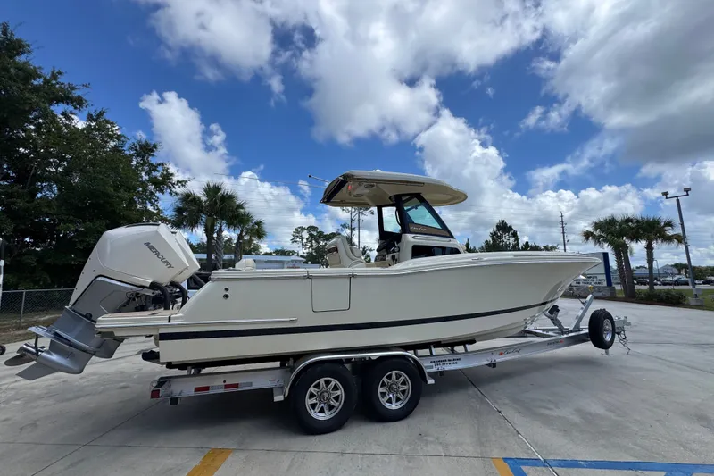 Slide: The Image of 2027 Chris-Craft Catalina 28 boat on trailer under a partly cloudy sky. - 12