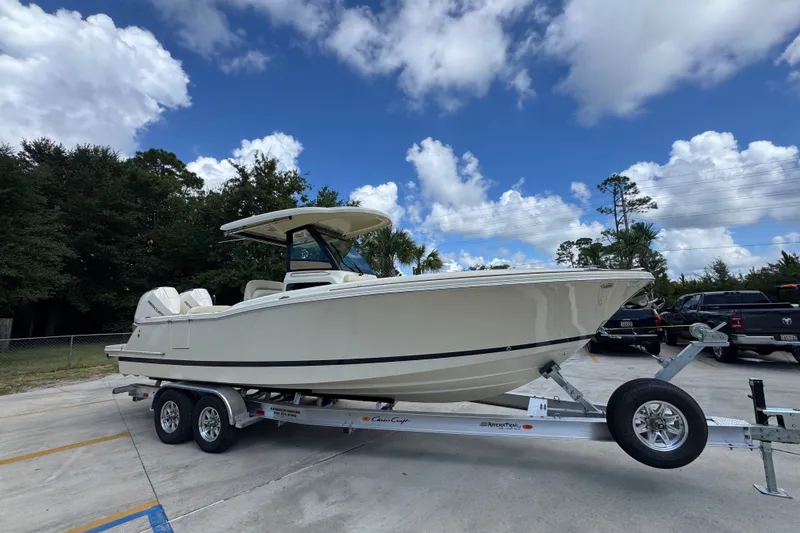 Slide: The Image of 2027 Chris-Craft Catalina 28 boat on trailer under a blue sky with clouds. - 9