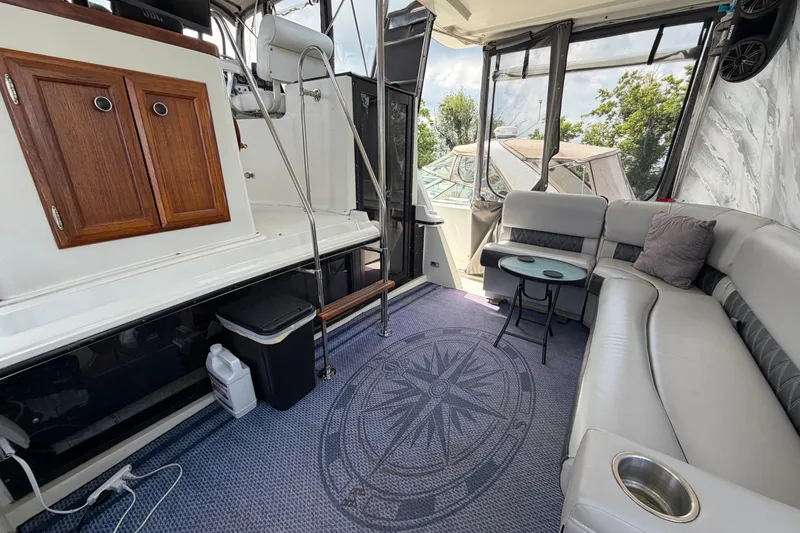 Slide: The Image of 1989 Carver 3607 Aft Cabin Motor Yacht interior with seating, table, and cabinetry. - 10