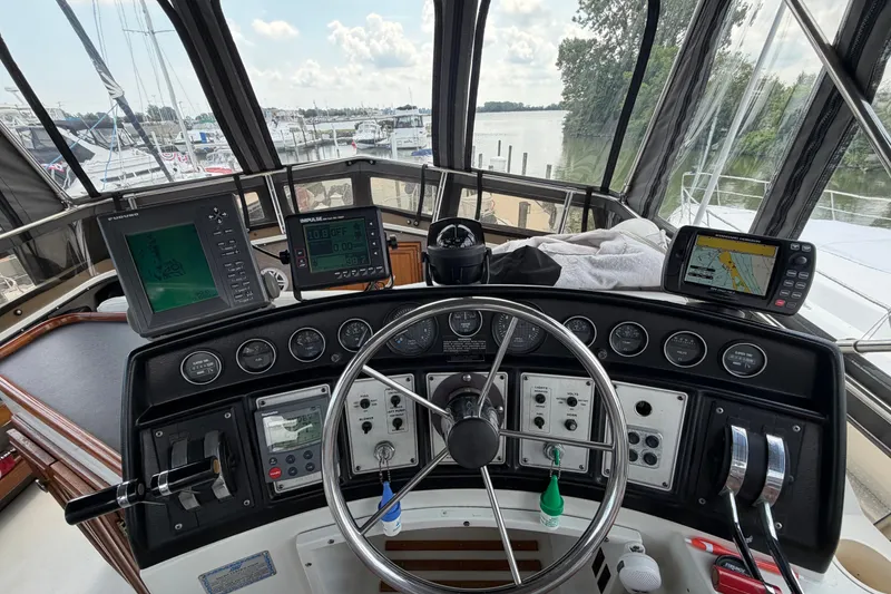 Slide: The Image of 1989 Carver 3607 Aft Cabin Motor Yacht helm with navigation instruments and steering wheel. - 14