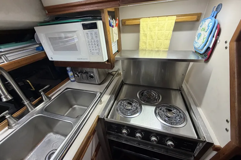 Slide: The Image of Compact kitchen in 1989 Carver 3607 Aft Cabin Motor Yacht with stove, microwave, and sink. - 26