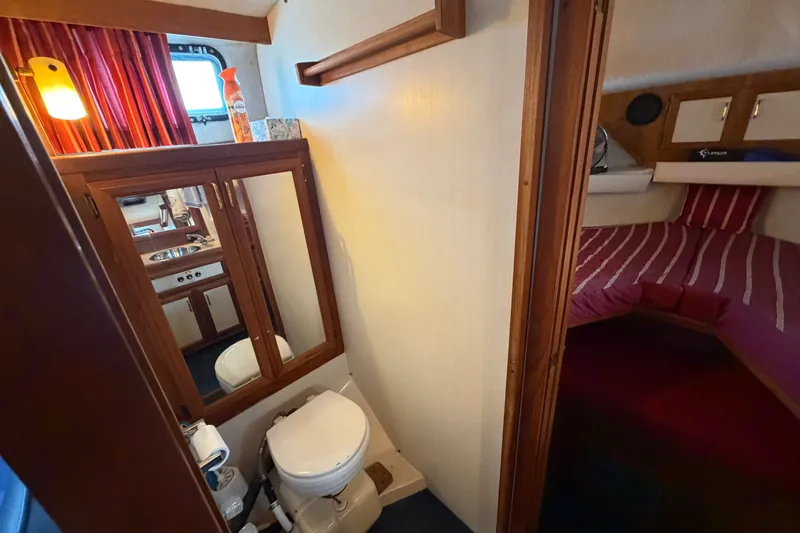 Slide: The Image of 1989 Carver 3607 Aft Cabin Motor Yacht bathroom and bedroom interior with wood accents. - 32