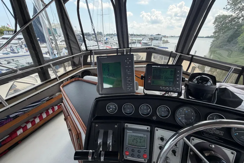 Slide: The Image of Helm of 1989 Carver 3607 Aft Cabin Motor Yacht with navigation instruments and marina view. - 15