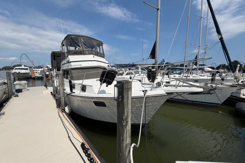 Slide: The Image of 1989 Carver 3607 Aft Cabin Motor Yacht docked at marina under blue sky. - 1