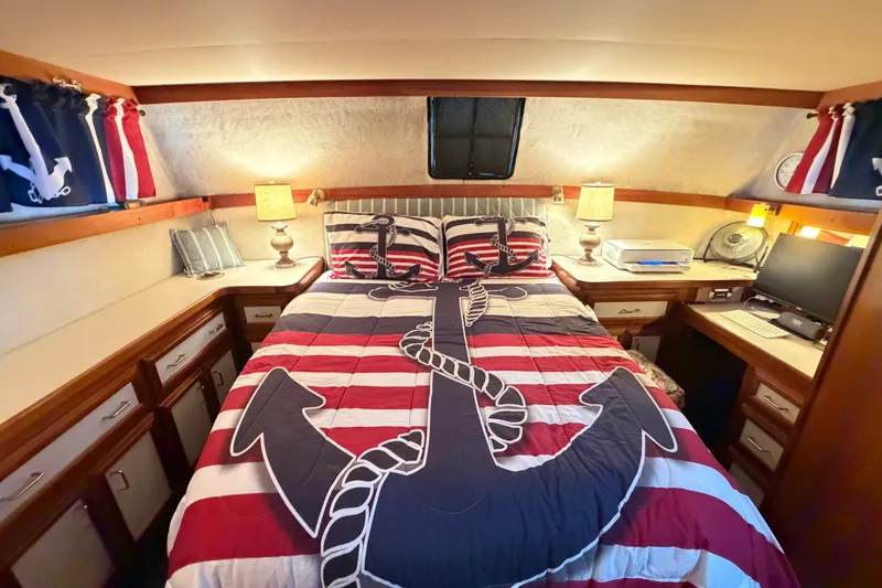 Slide: The Image of 1989 Carver 3607 Aft Cabin Motor Yacht bedroom with nautical-themed decor and anchor bedding. - 36