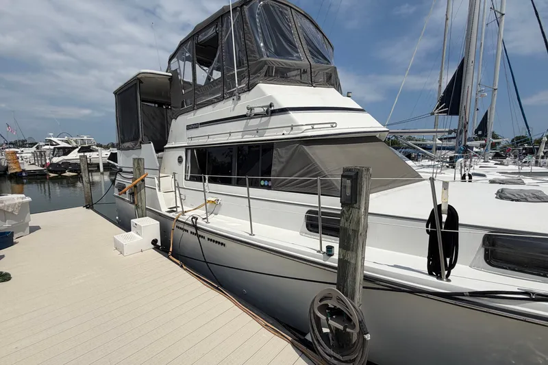 Slide: The Image of 1989 Carver 3607 Aft Cabin Motor Yacht docked at marina under blue sky. - 6