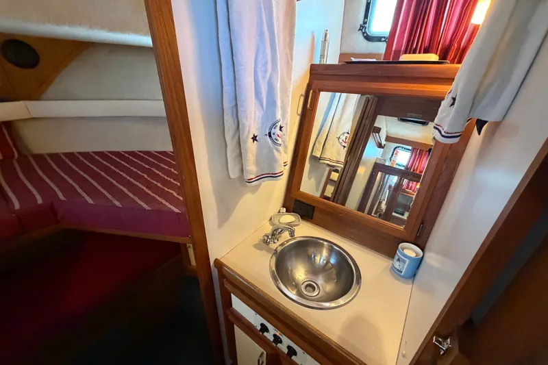 Slide: The Image of 1989 Carver 3607 Aft Cabin Motor Yacht interior with sink, mirror, and cozy cabin. - 33