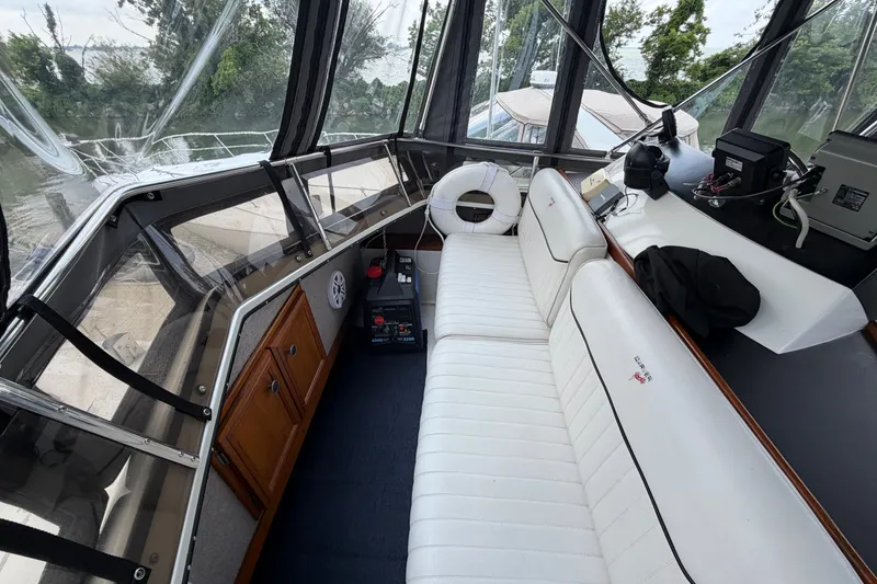 Slide: The Image of 1989 Carver 3607 Aft Cabin Motor Yacht interior with white seating and navigation equipment. - 18