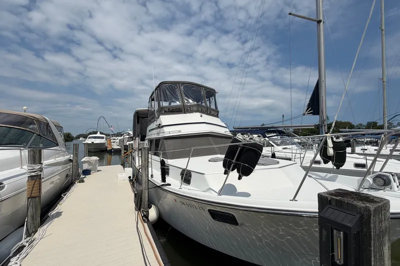Slide: The Image of 1989 Carver 3607 Aft Cabin Motor Yacht docked at marina under cloudy sky. - 5
