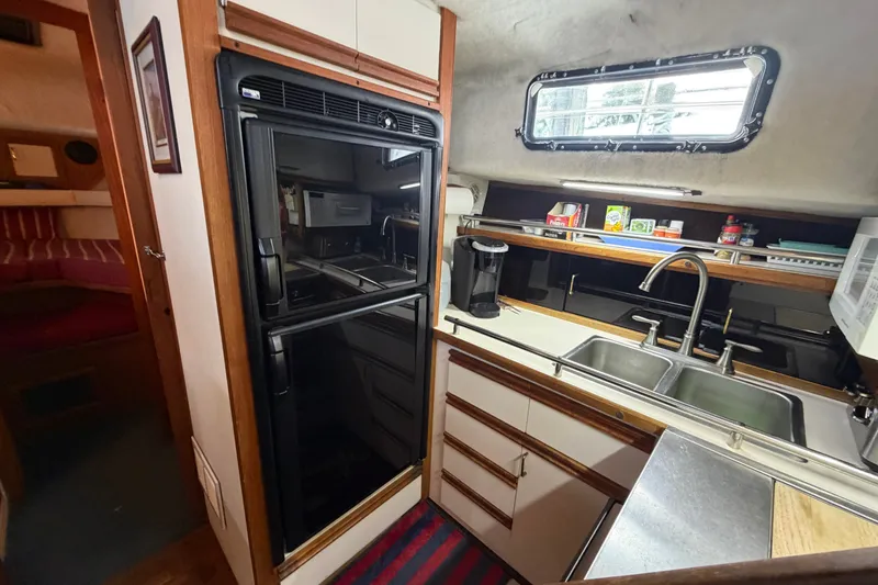Slide: The Image of 1989 Carver 3607 Aft Cabin Motor Yacht kitchen with sink, fridge, and window. - 28