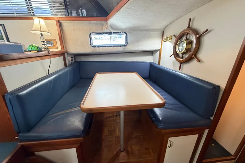 Slide: The Image of 1989 Carver 3607 Aft Cabin Motor Yacht interior with blue seating and nautical decor. - 24
