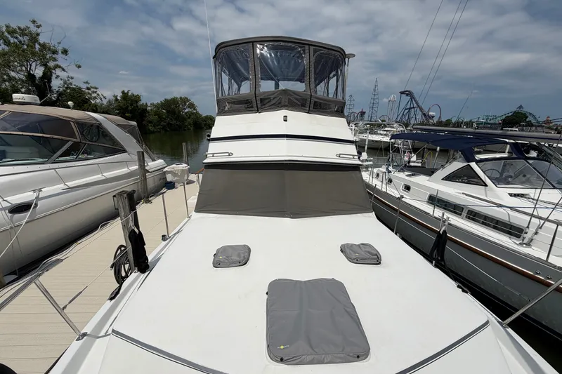 Slide: The Image of 1989 Carver 3607 Aft Cabin Motor Yacht docked at marina, clear sky background. - 3
