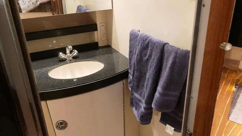 Slide: The Image of 2008 Regal 3760 yacht bathroom with sink, black countertop, and purple towels. - 42