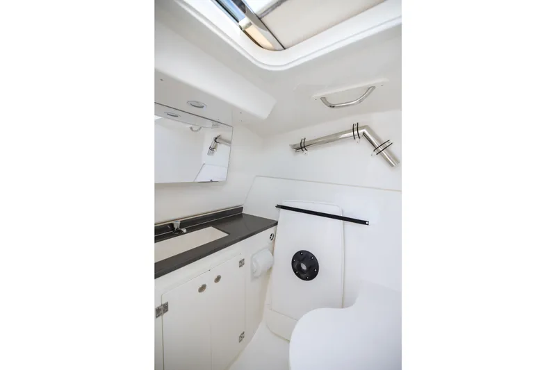 Slide: The Image of 2026 Pursuit DC 326 Dual Console boat interior with sleek white cabinetry and modern fixtures. - 25