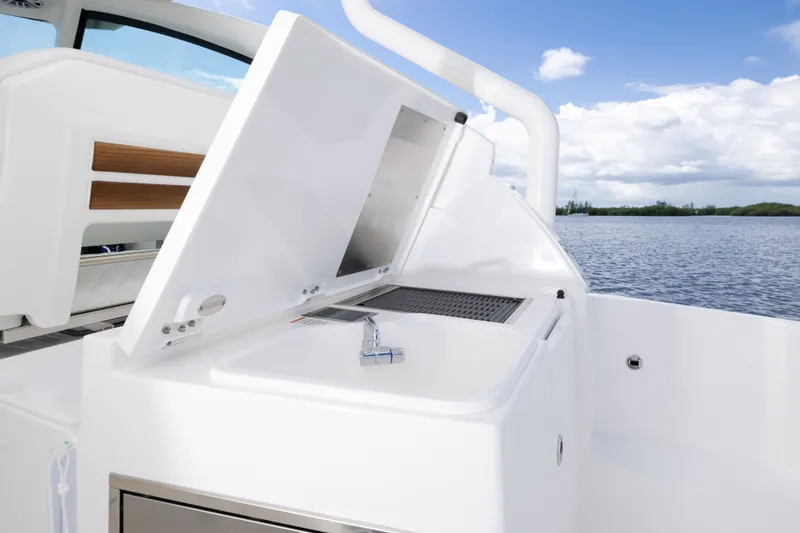 Slide: The Image of 2026 Pursuit DC 326 Dual Console boat with open sink, lake view, and clear sky. - 20